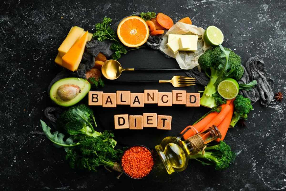 A variety of healthy foods arranged in a circle including vegetables like broccoli, carrots, and avocado