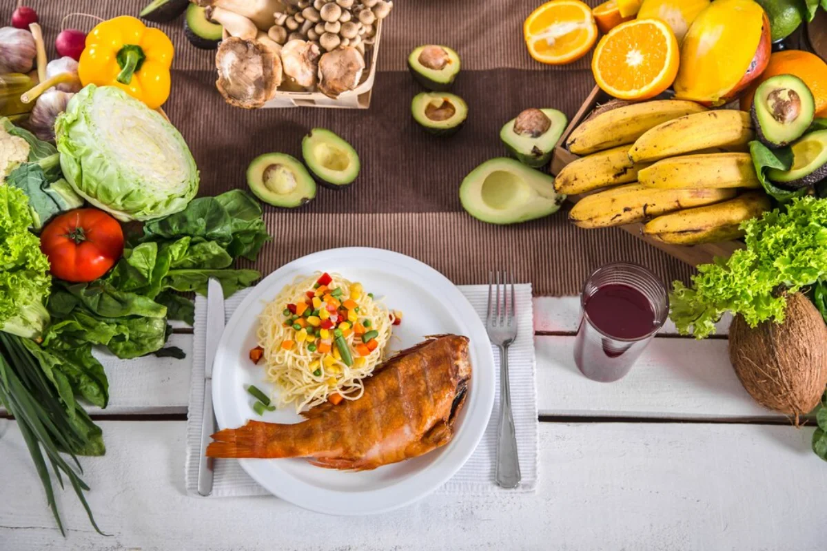 A healthy meal setup featuring grilled fish and spaghetti with mixed vegetables