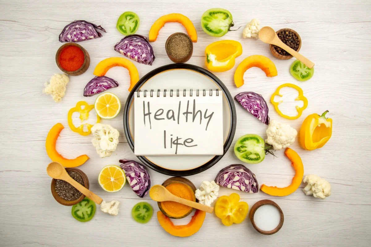 A flat lay including a variety of vegetables and a notepad with 