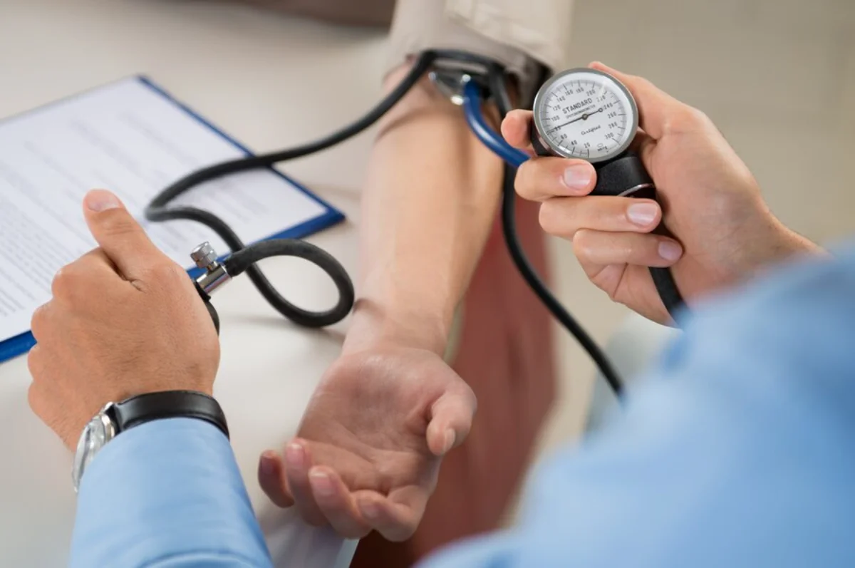 A healthcare professional is measuring a patient's blood pressure using a sphygmomanometer.