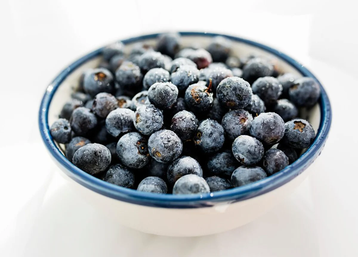 A bowl of fresh blueberries with visible water droplets
