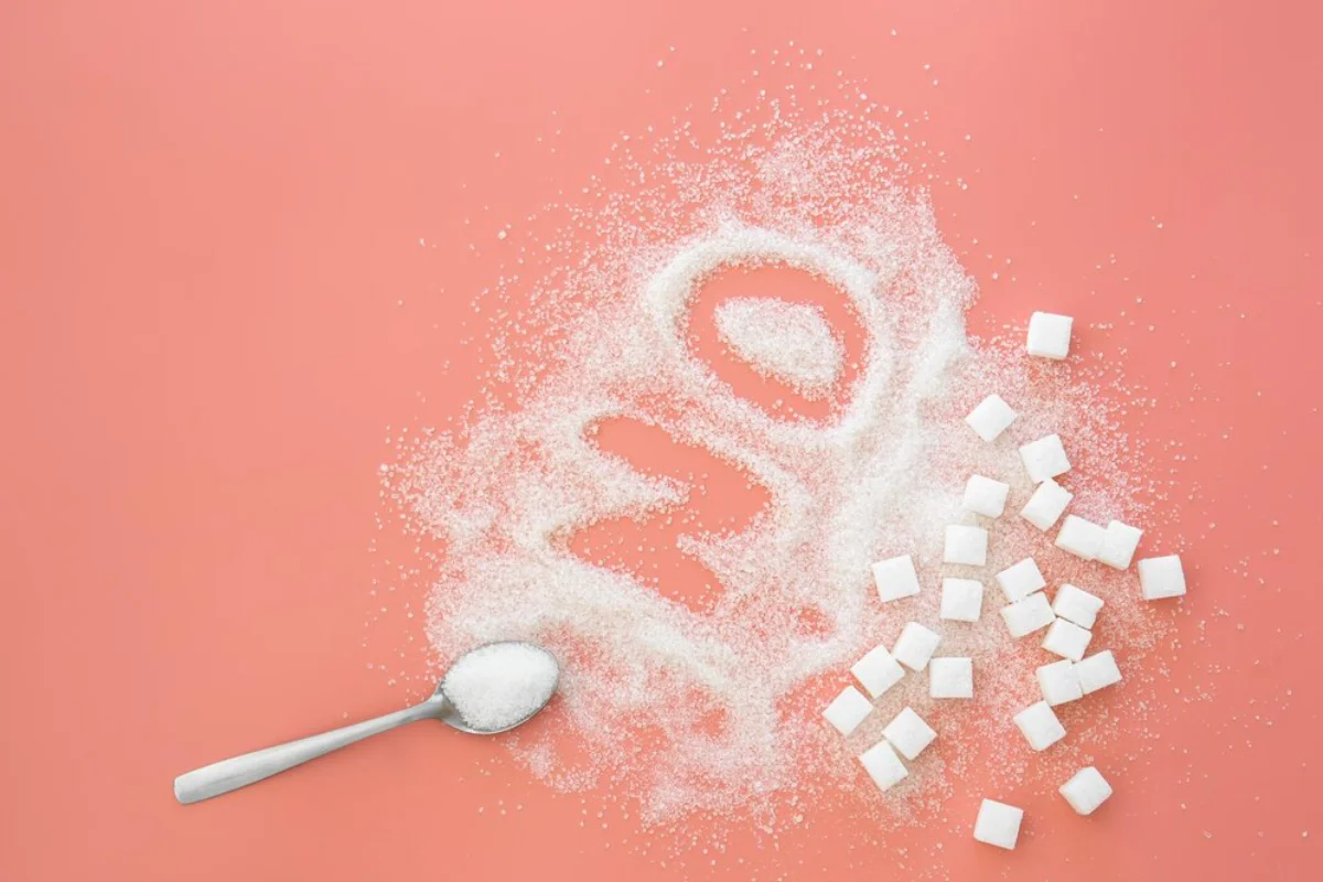 A creative representation of a sugar skull made from granulated sugar and cubes, with a spoonful of sugar