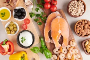 A variety of Mediterranean ingredients arranged on a table, featuring a raw salmon steak