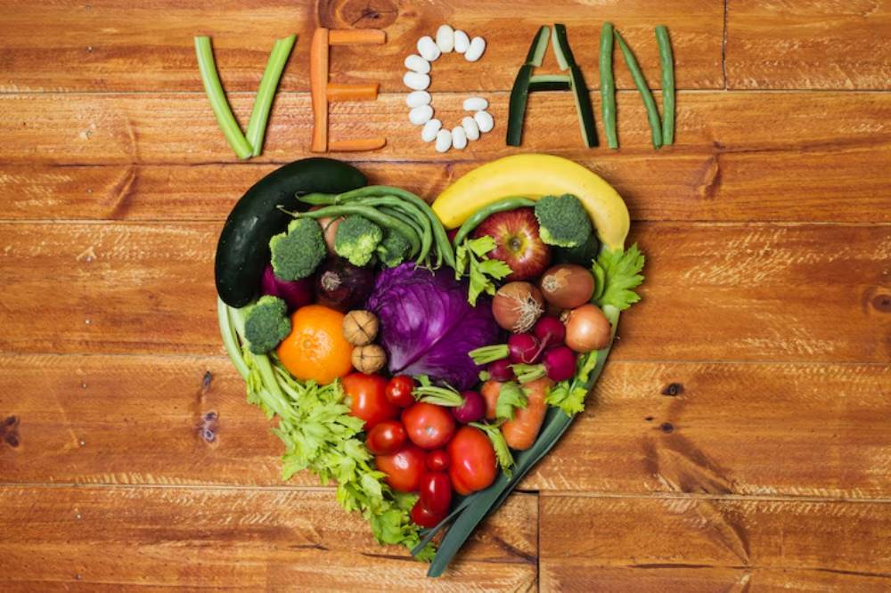 A heart-shaped arrangement of colorful vegetables and fruits, with 